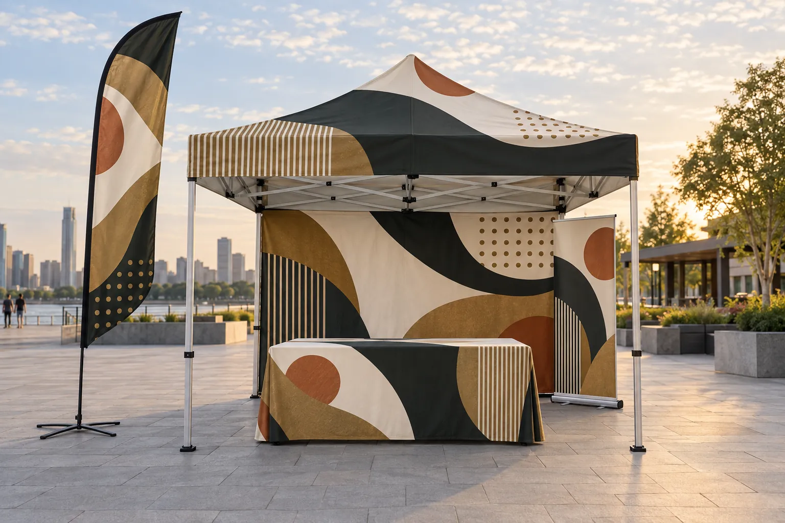 A complete outdoor booth: a printed canopy tent with a back wall, a fitted table cover, a feather flag and a roll up banner, all in one abstract design