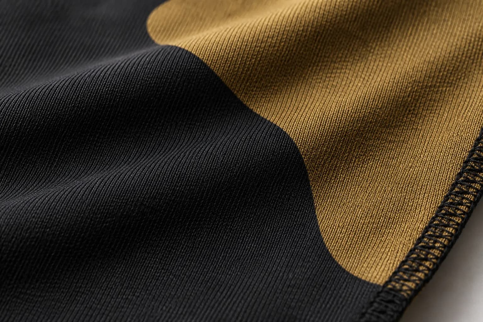 Close up of dye sublimated polyester knit, showing the weave and a serged edge